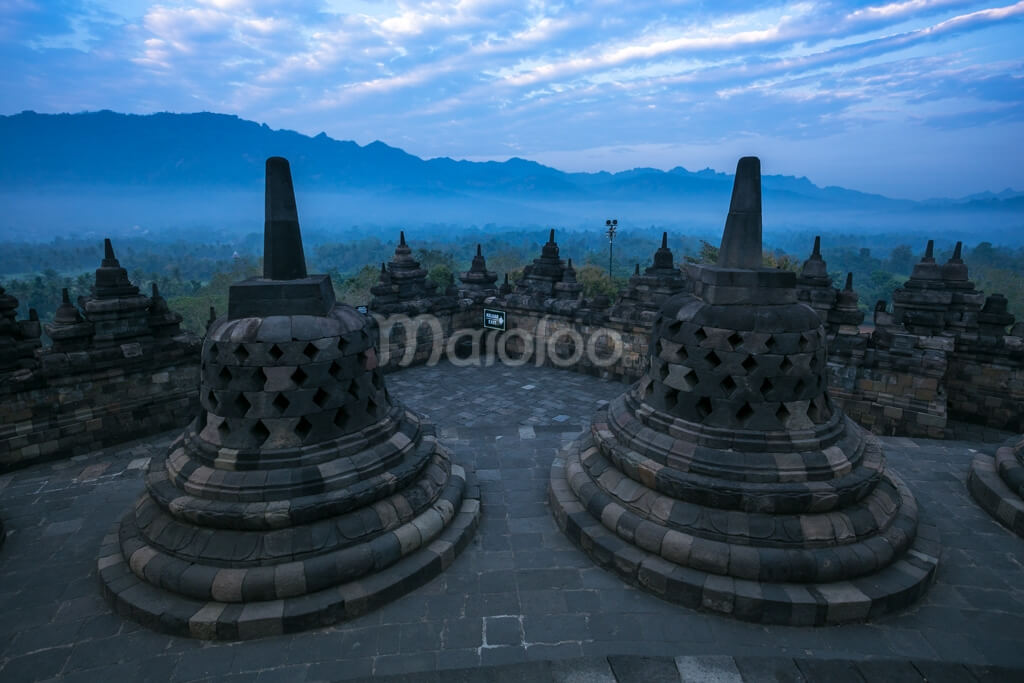 Borobudur Temple's stupas with Menoreh Hills in the background.