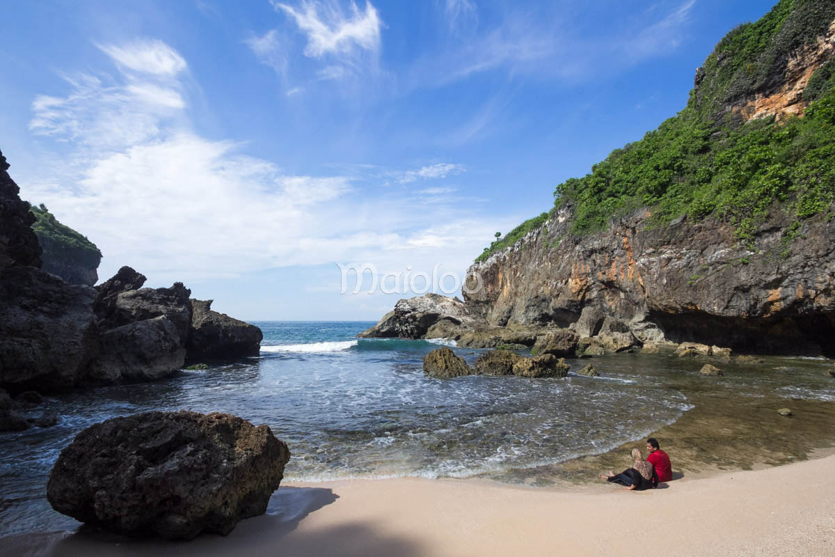 Tourists enjoying the beauty of Wohkudu Beach with its rocky shore and clear blue waters.