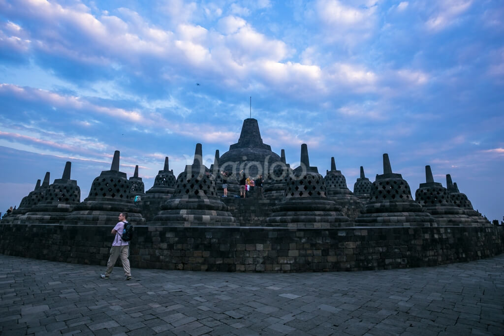 Tourists exploring Borobudur Temple at sunrise.