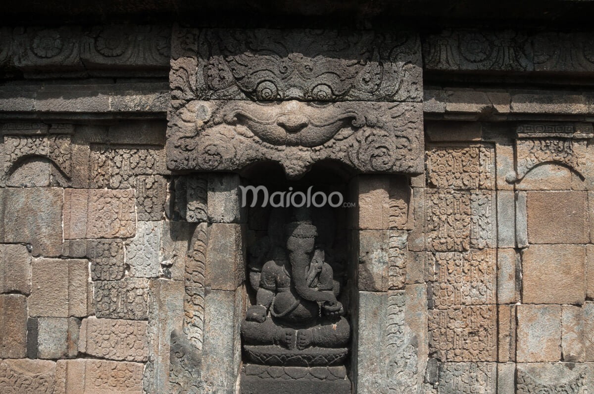 A detailed stone carving of Ganesha on the eastern side of Sambisari Temple.