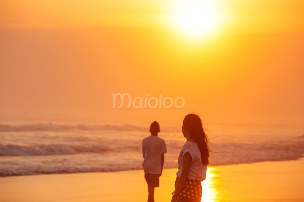 Two people watching the sunset at Parangtritis Beach.