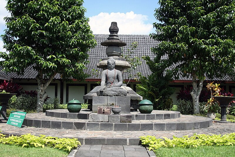 Stone Buddha statue in a garden at Karmawibhangga Museum