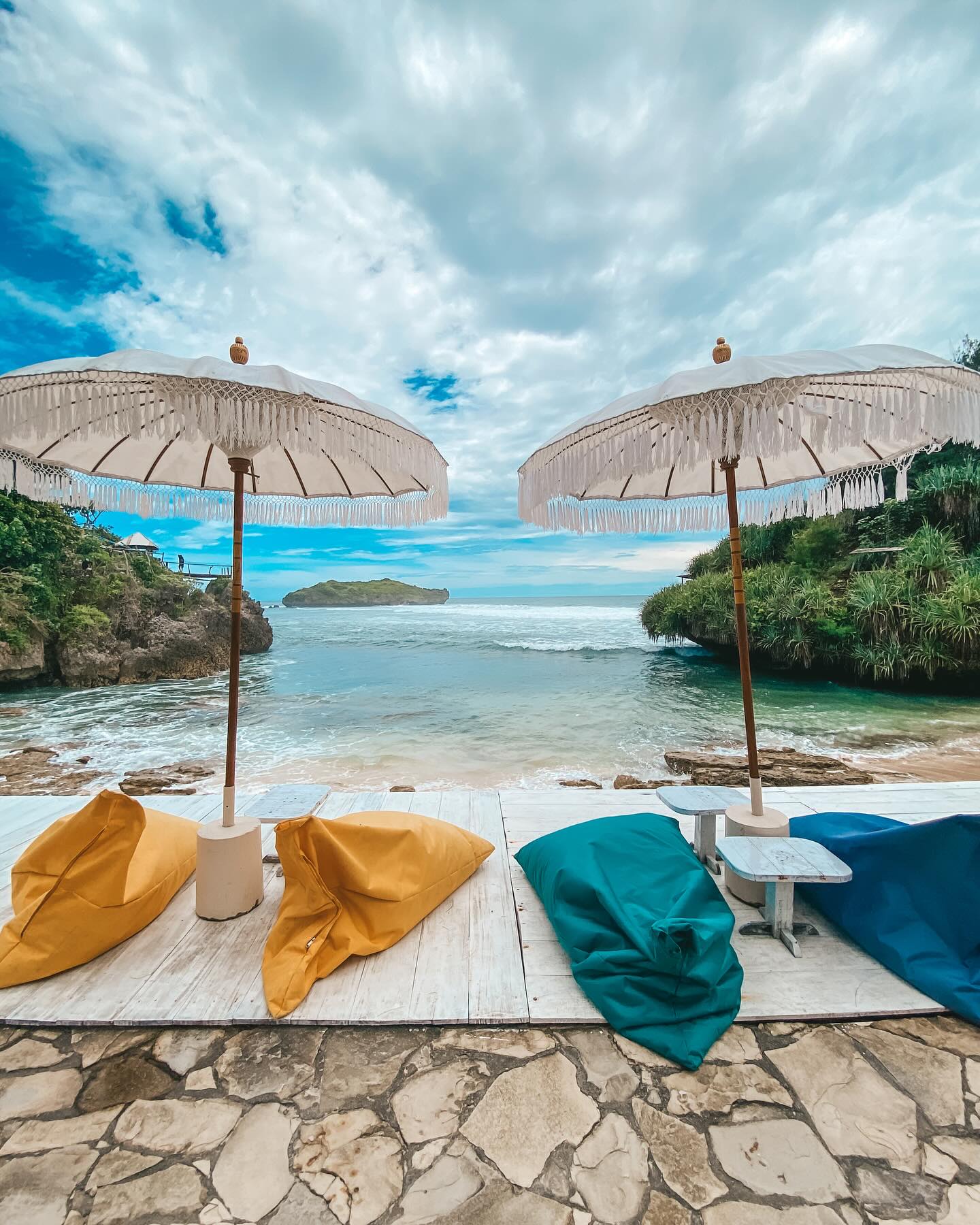 Beachside lounge area with colorful bean bags and umbrellas overlooking the ocean at Slili Beach.