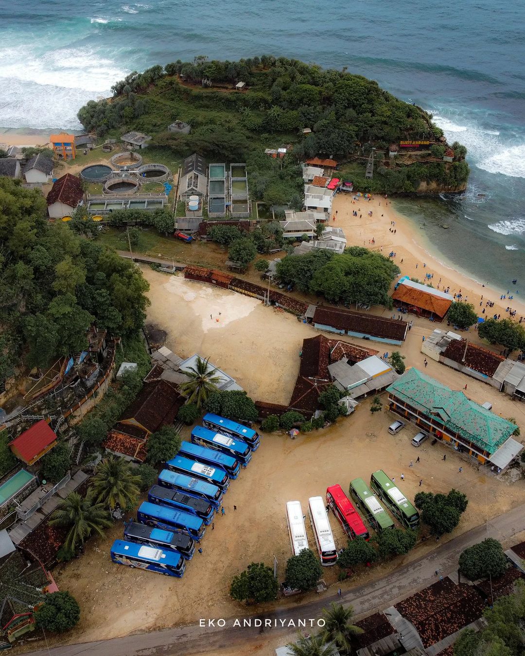 Aerial view of Indrayanti Beach with parked buses and surrounding facilities.