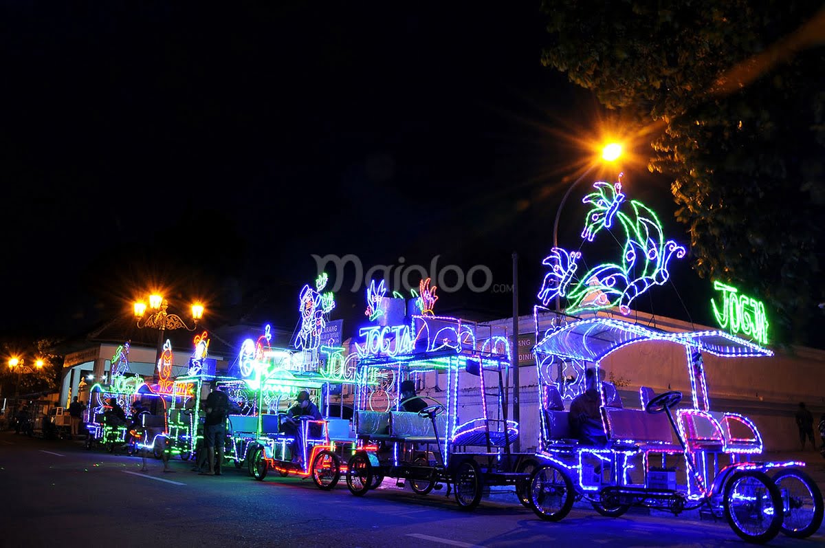 Colorful decorated bicycles line the street at night at Alun-Alun Kidul in Yogyakarta.