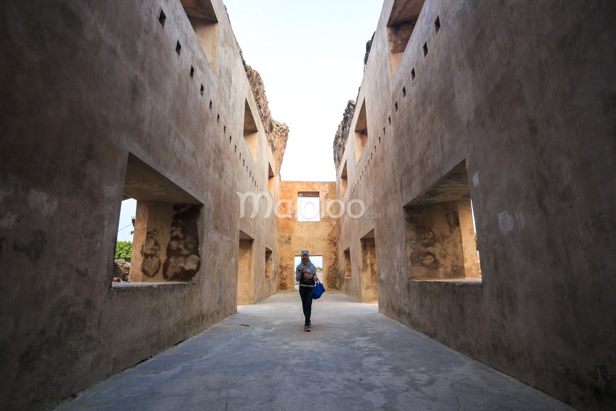 A person walks through the ground level of Gedhong Kenongo, a tall, two-story building in Taman Sari, Yogyakarta.