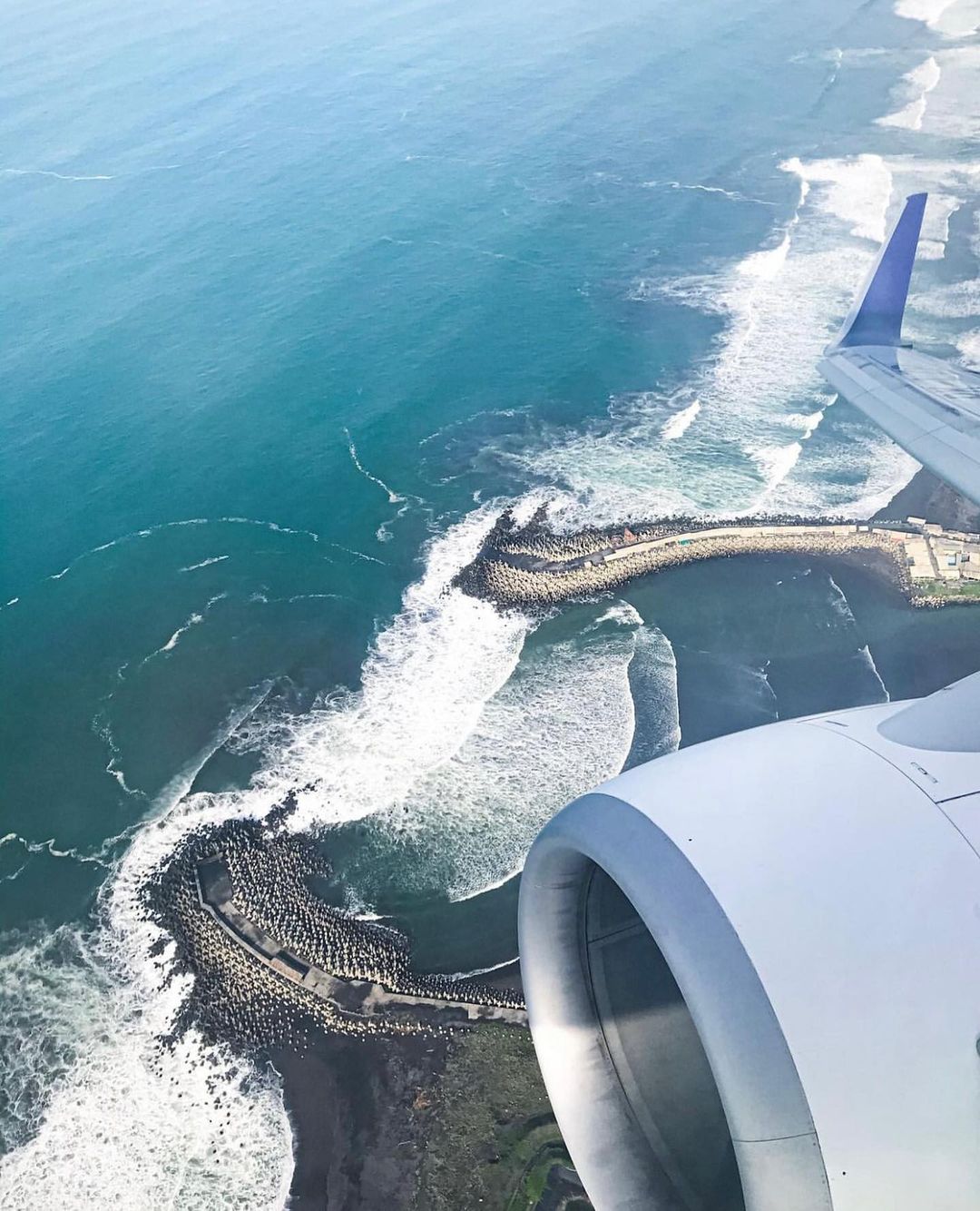 Aerial view of Glagah Beach and its wave breakers from an airplane.