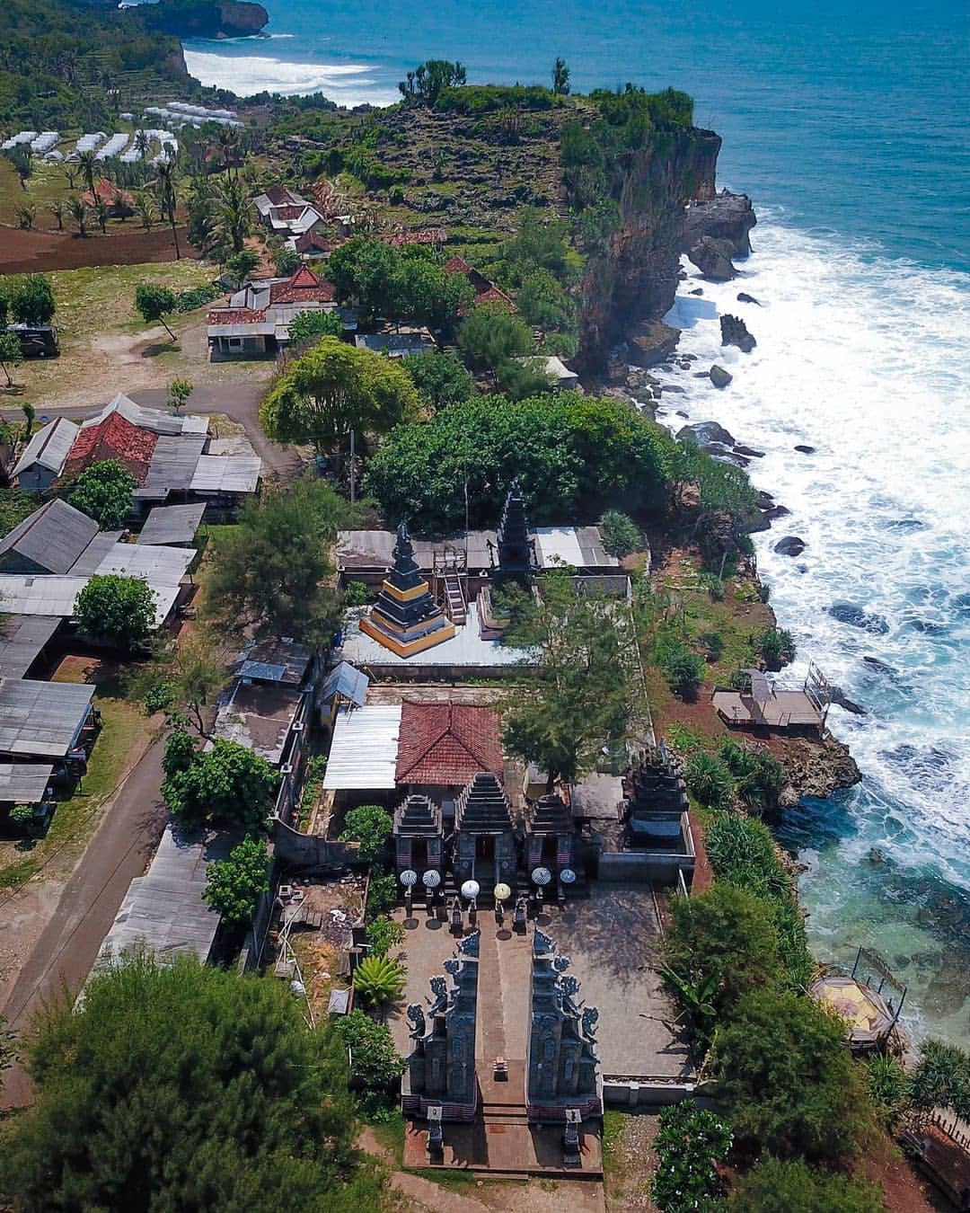 Aerial view of Ngobaran Beach, showcasing the Hindu temple complex and coastal cliffs.