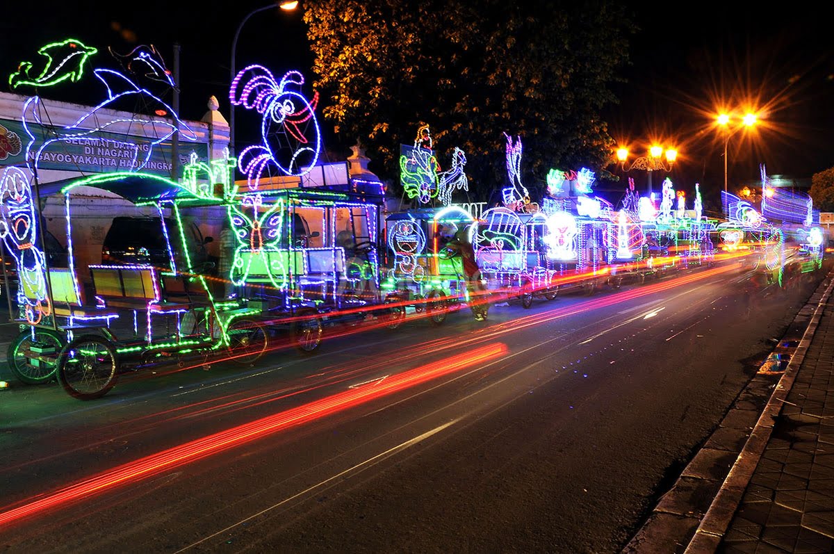 Colorful decorated bicycles line the street at night at Alun-Alun Kidul in Yogyakarta.