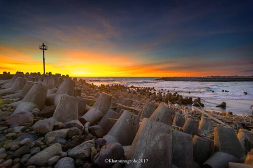 Sunset view at Glagah Beach with concrete wave breakers.