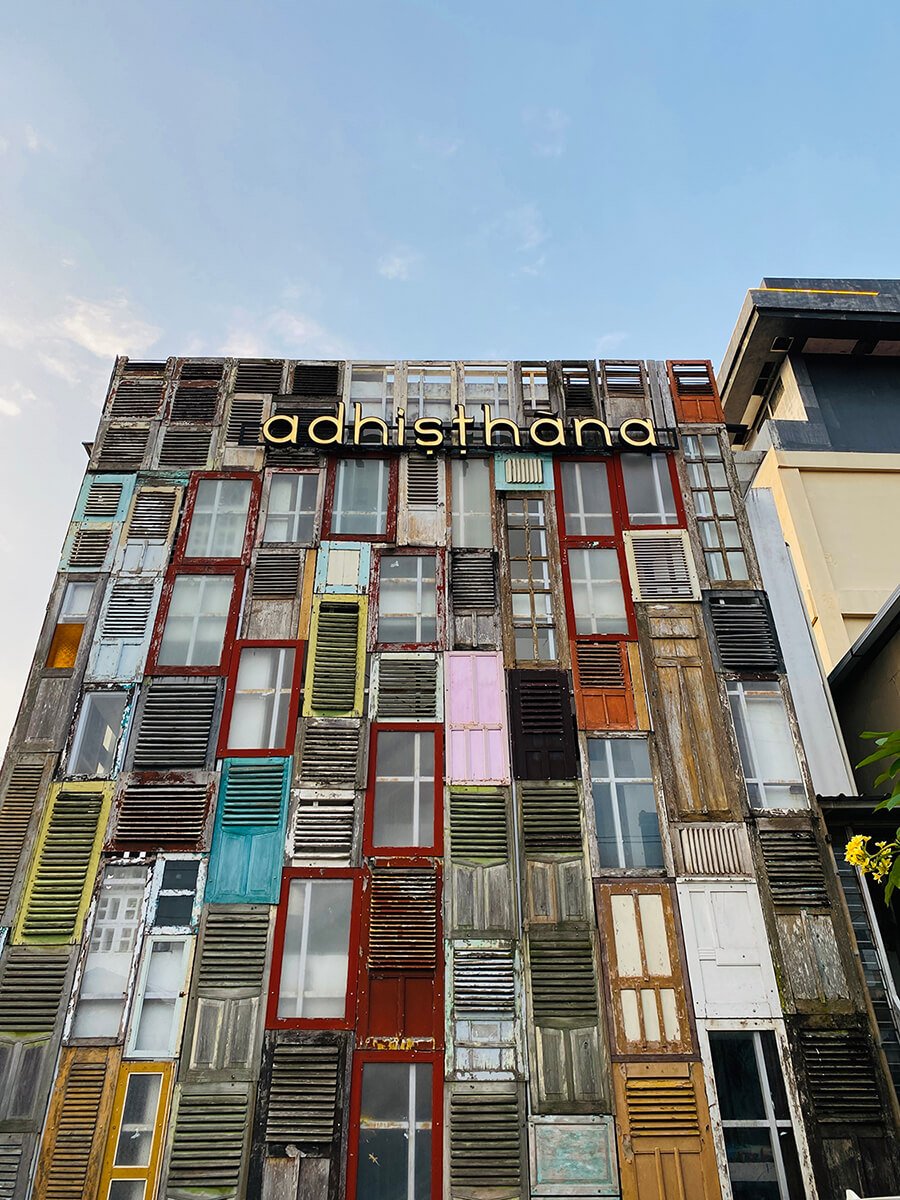 Colorful facade of Adhisthana Hotel made from various old windows and doors.