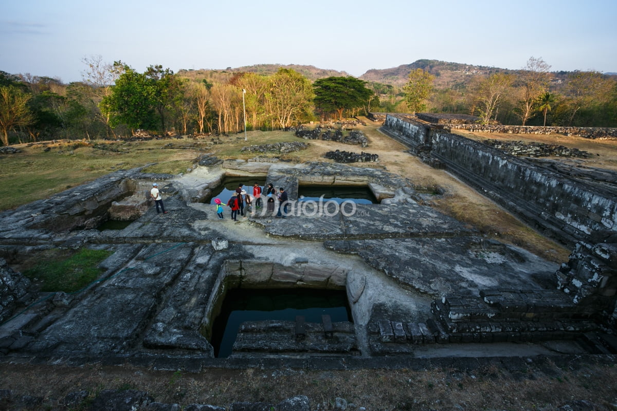 Visitors standing near the ancient water ponds at Ratu Boko Palace.