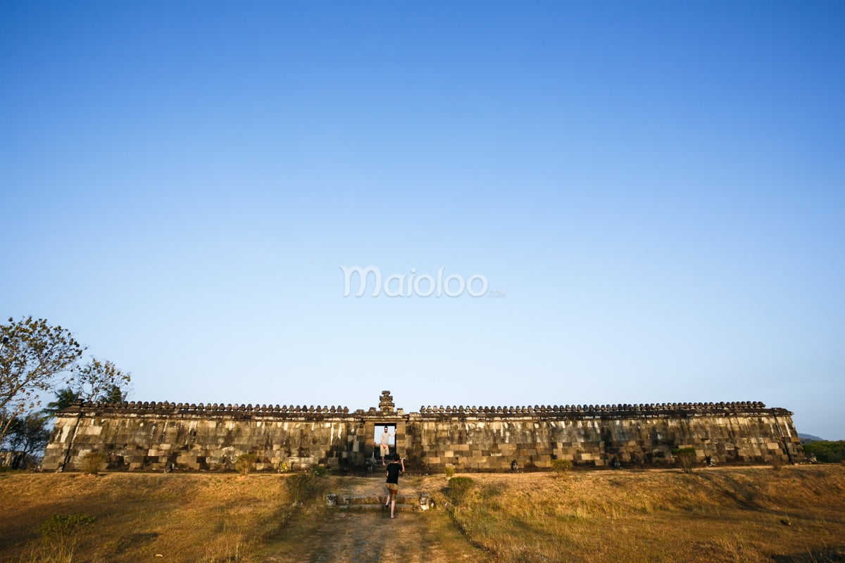 People walking toward the Pendopo pavilion at Ratu Boko Palace.