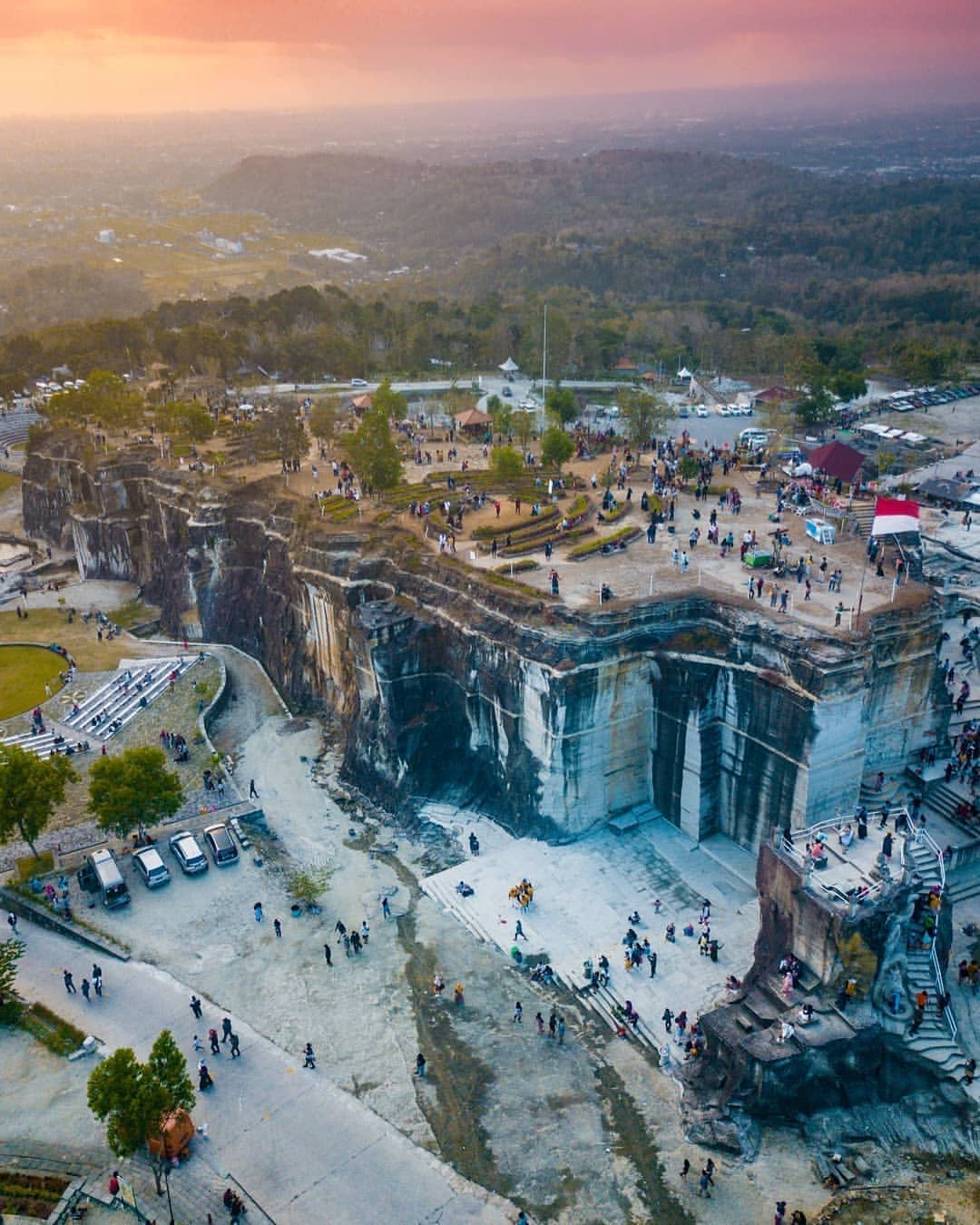 Aerial view of Breksi Cliff with visitors exploring the area at sunset.