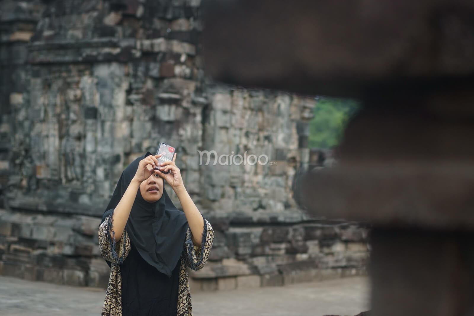 A visitor taking a photo at Sewu Temple in Central Java.