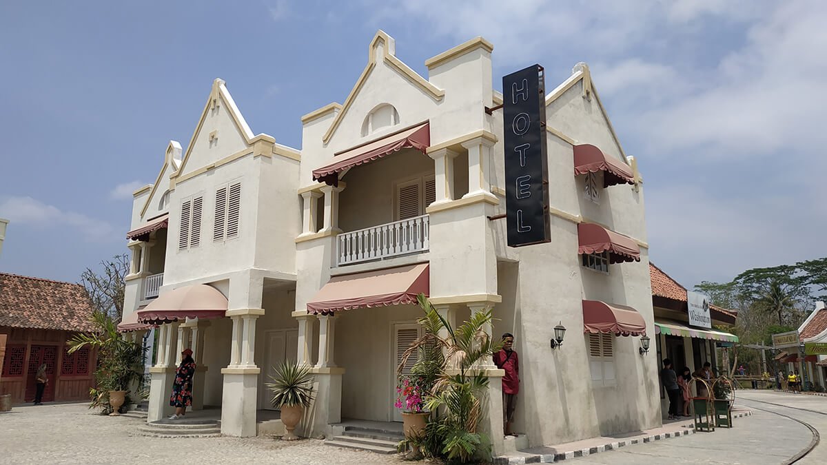 A vintage hotel building with balconies at Gamplong Studio Alam.