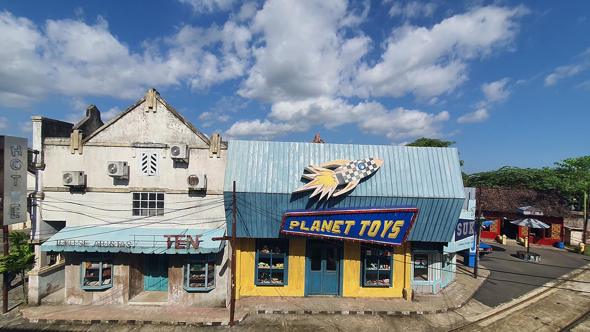 A toy store and an old building on a sunny day at Gamplong Studio Alam.