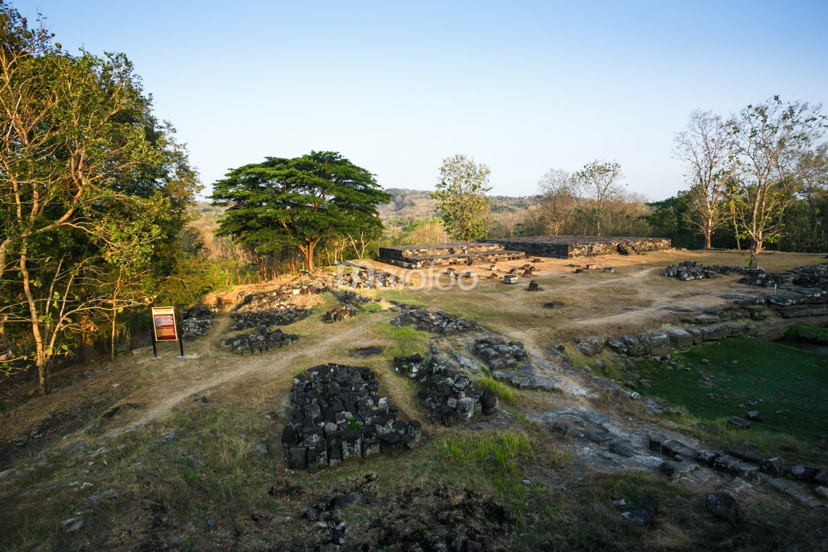 Ancient ruins surrounded by trees and hills at Ratu Boko Palace.