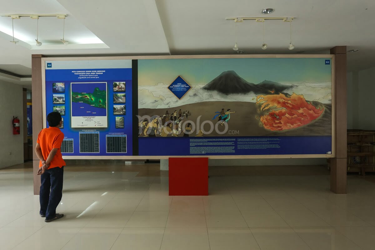 A visitor reading an informational panel about the myths of Mount Bromo, specifically "Rara Anteng & Joko Seger."