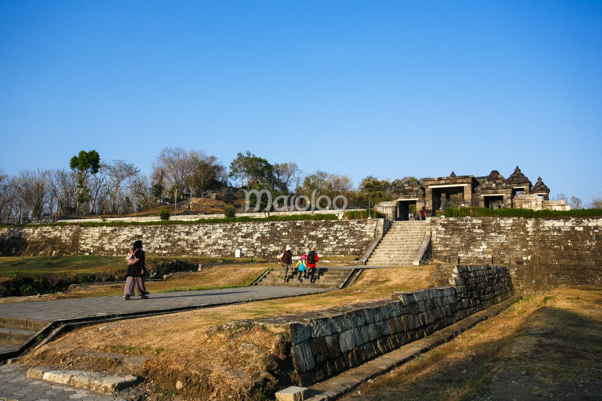 Visitors walk towards the main entrance gate of Ratu Boko Palace.