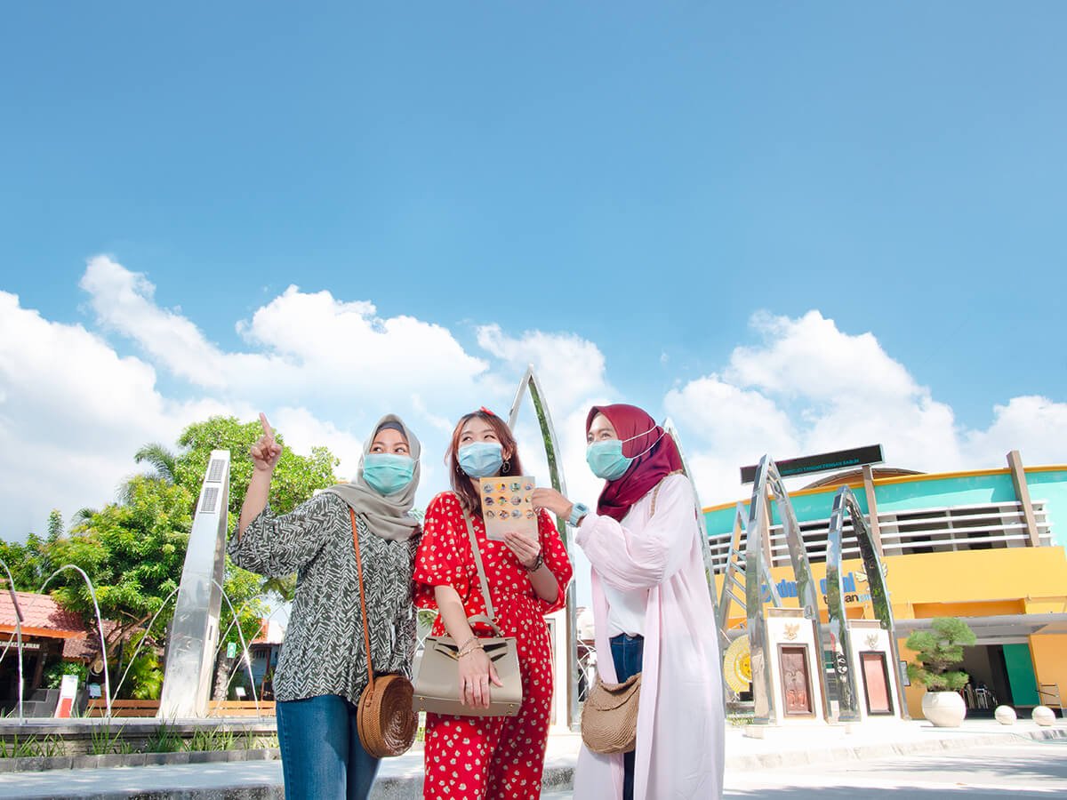 Three visitors exploring Taman Pintar Yogyakarta outdoors.