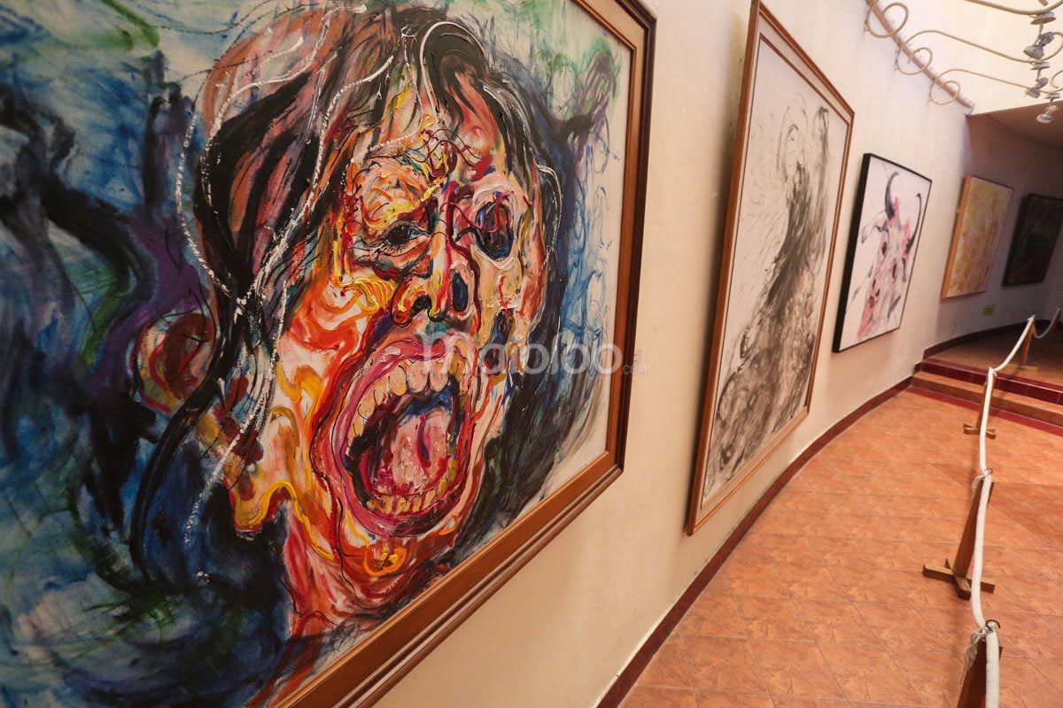 A row of expressive and colorful paintings lined up on the wall in Affandi Museum's third gallery.