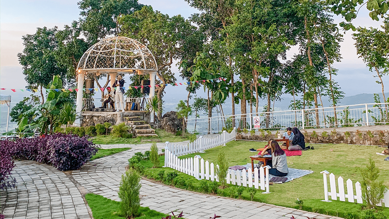 People enjoying picnics and live music at De Mangol View's garden area.