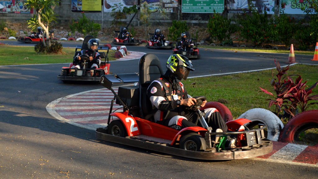 Kids driving go-karts around a curved track at Kids Fun Park.