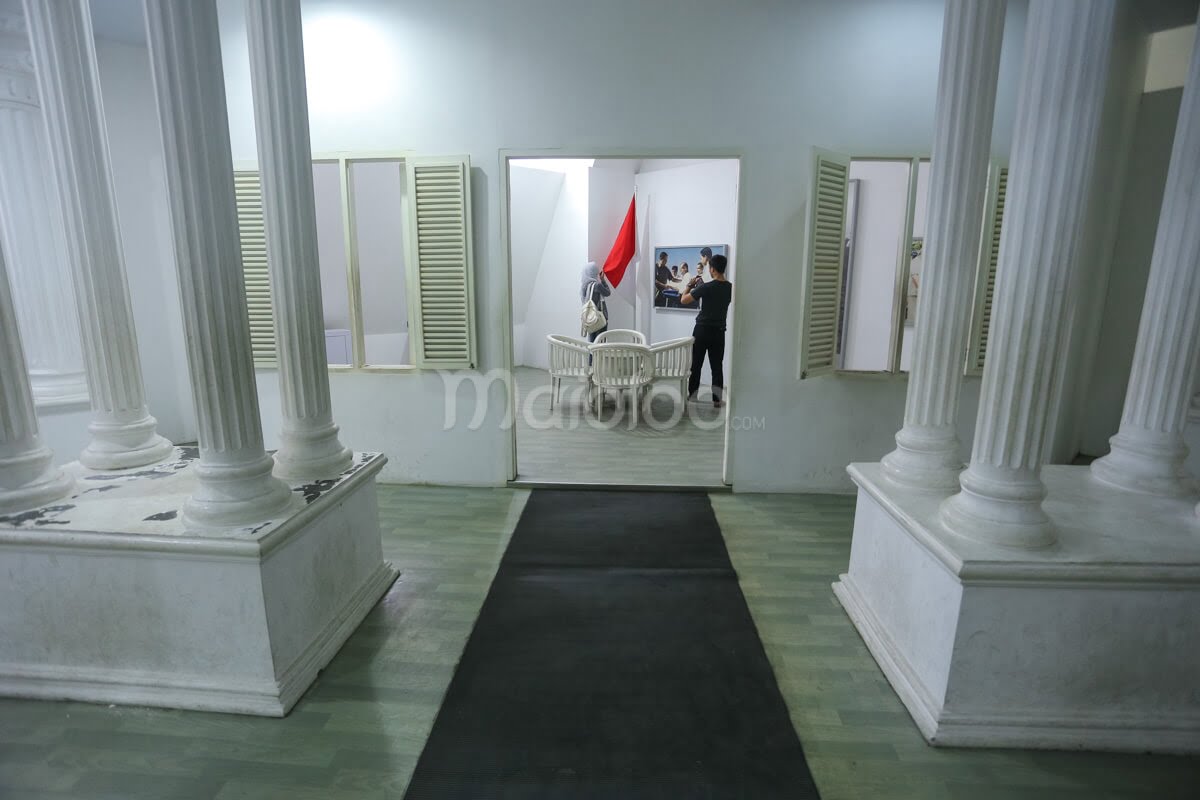 Two visitors exploring the historical room at Merapi Volcano Museum.