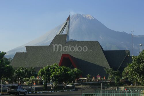 The front view of Merapi Volcano Museum with Mount Merapi in the background.