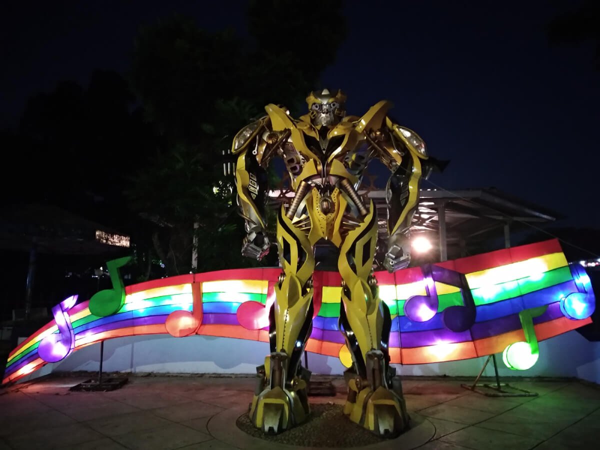 A robot statue with a colorful musical notes background at Taman Pelangi in Yogyakarta.