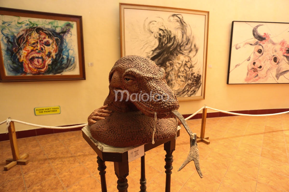 A sculpture and several expressive paintings displayed in the Affandi Museum.