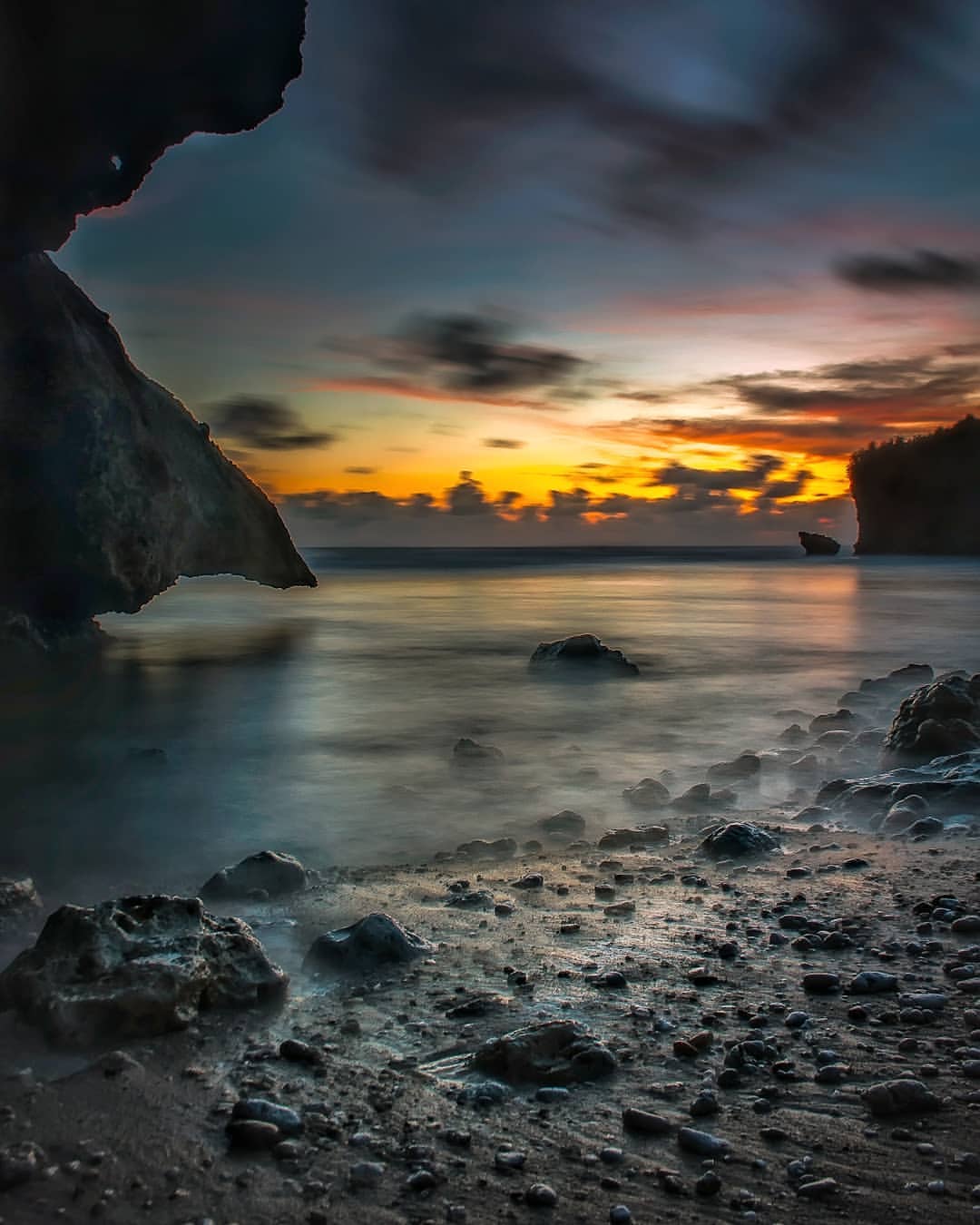 Sunset over the rocky shore of Pringjono Beach.