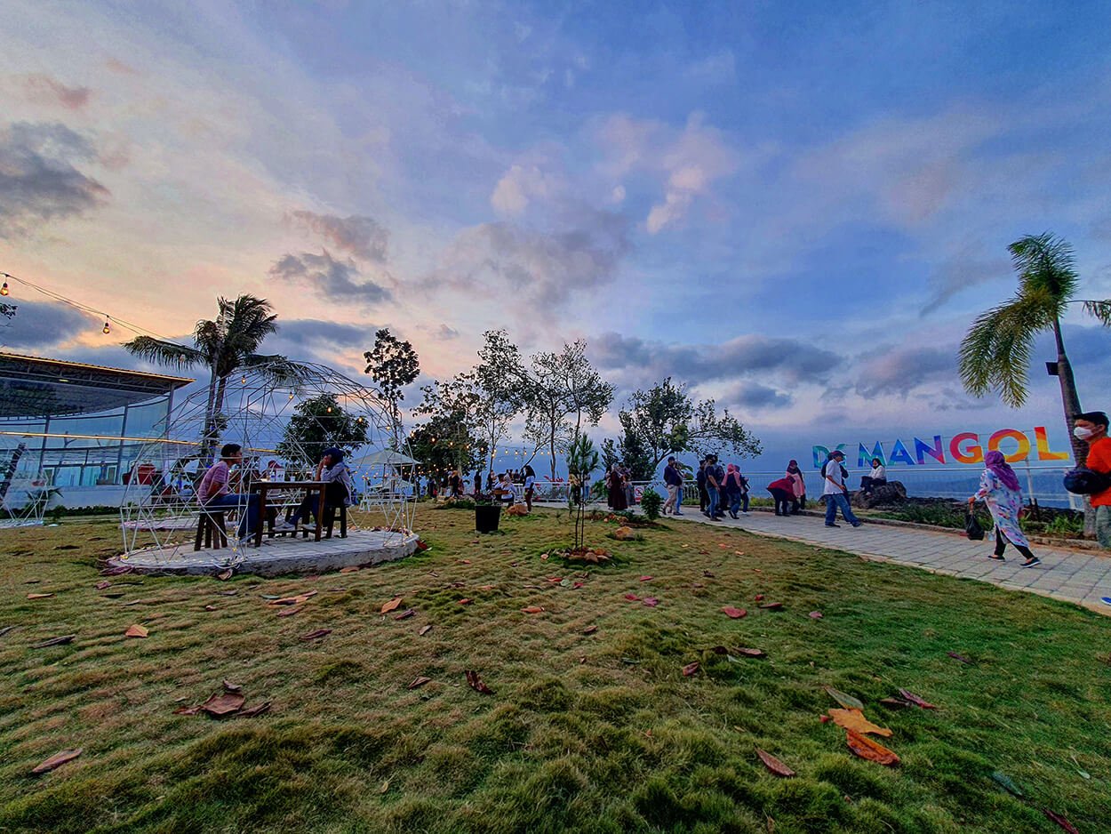 People enjoying the outdoor area at De Mangol View during sunset.