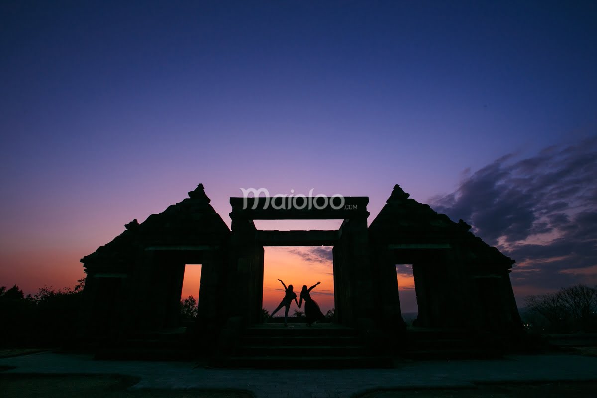 Vibrant sunset behind ancient gate at Ratu Boko Palace.
