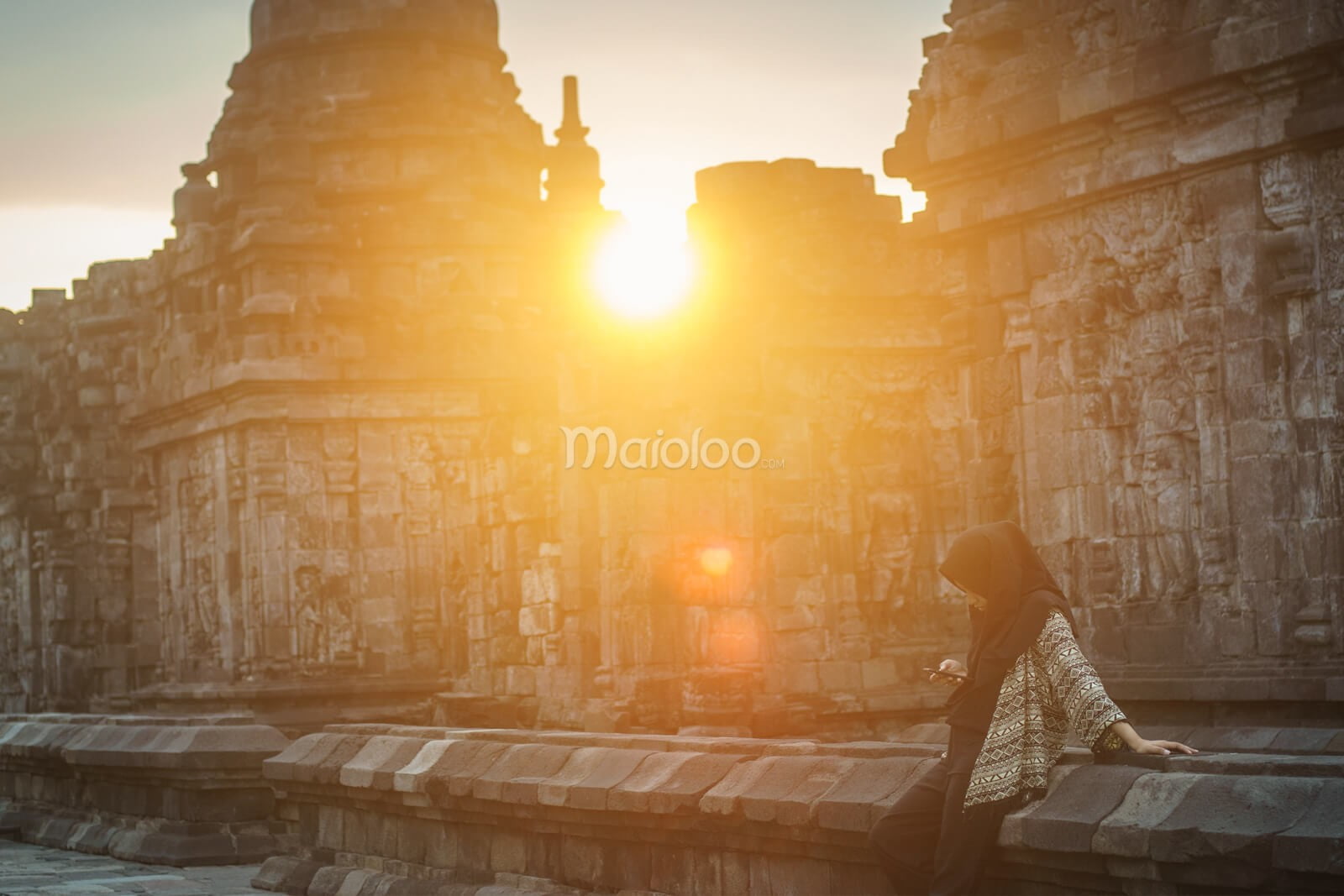 A visitor enjoys the sunset at Sewu Temple in Klaten, Central Java.