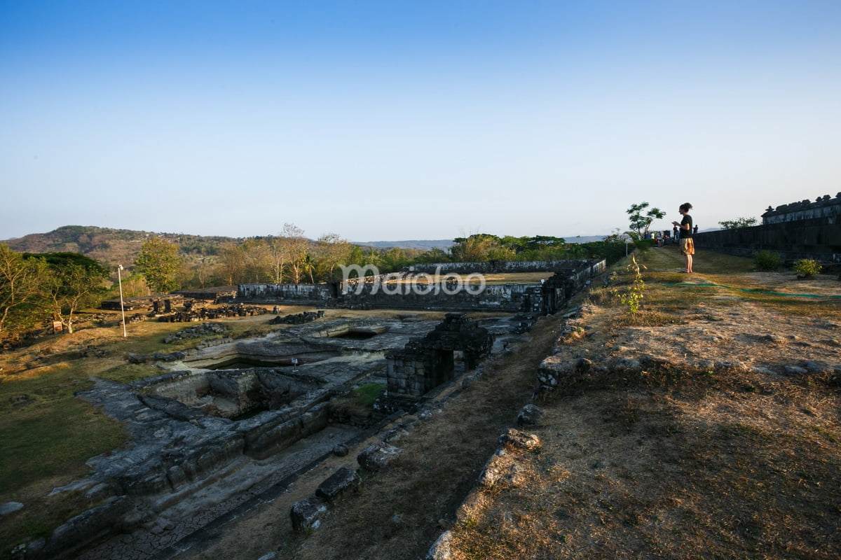 A tourist observing the ancient water ponds complex at Ratu Boko Palace.