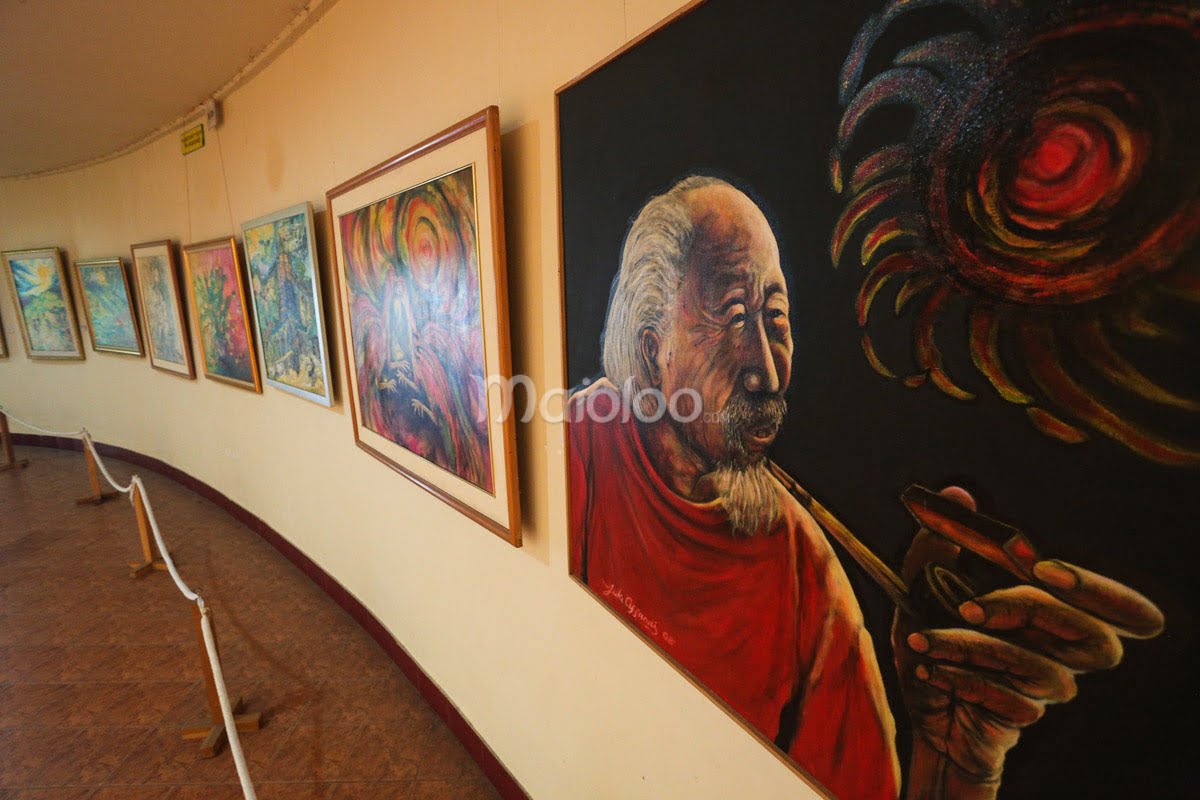 A row of colorful paintings, including a portrait of a man in red holding a pipe, displayed in Affandi Museum's third gallery.