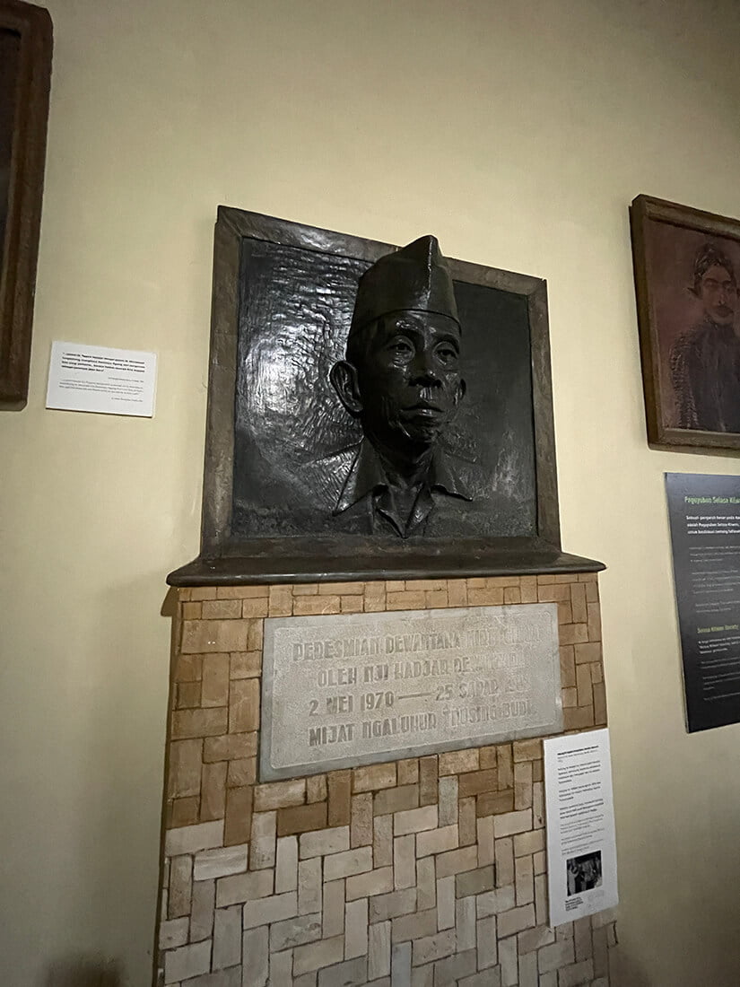 A bronze relief sculpture of Ki Hajar Dewantara on a pedestal inside Dewantara Kirti Griya Museum.