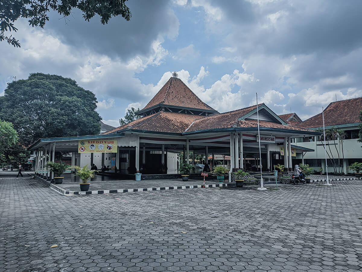 A large building with traditional red-tiled roof and open space at Dewantara Kirti Griya Museum.