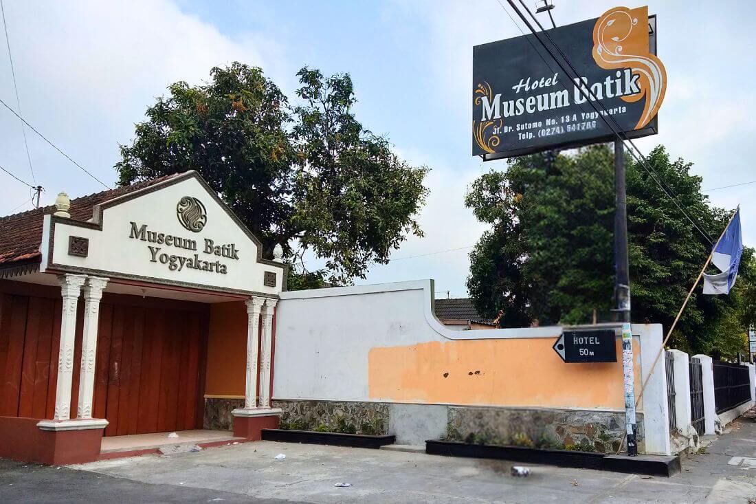 The entrance of Museum Batik Yogyakarta with a signboard on the side.