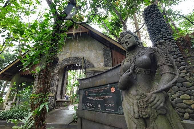 A stone statue and entrance gate at Ullen Sentalu Museum.