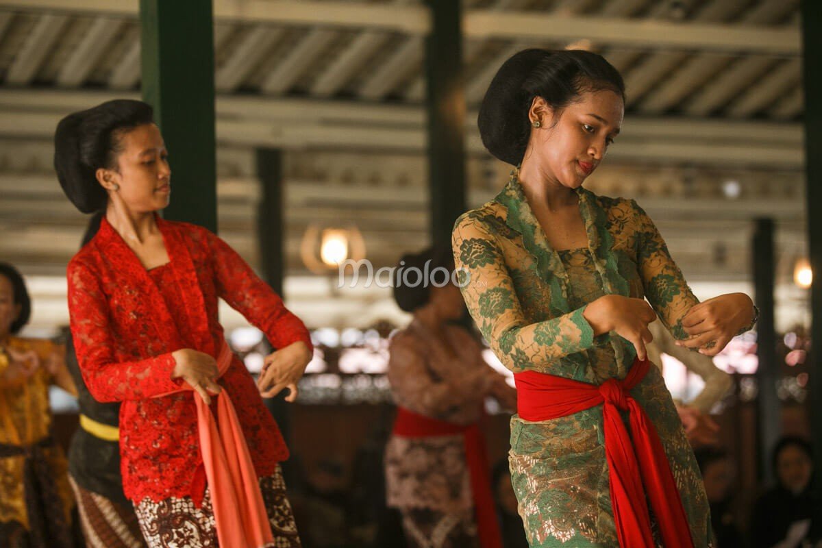 Two traditional dancers performing with graceful movements at Bangsal Sri Manganti in Yogyakarta Palace.