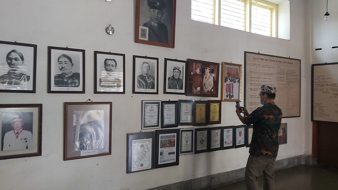 A man views historical photos and memorabilia on a wall at Pura Pakualaman Museum.