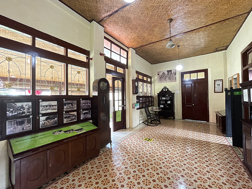 Interior view of Dewantara Kirti Griya Museum displaying old photos and vintage furniture.