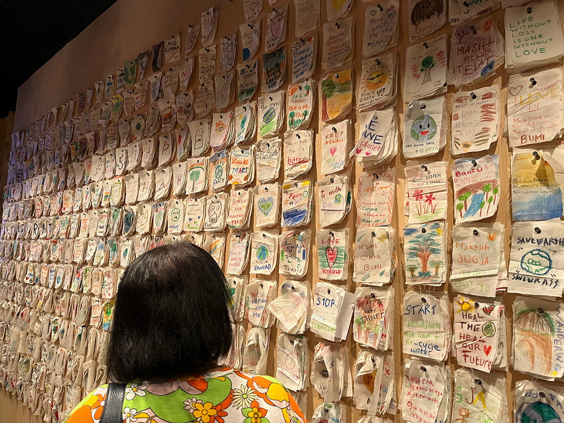 A wall filled with colorful handwritten messages and drawings at a temporary exhibition in Jogja National Museum.