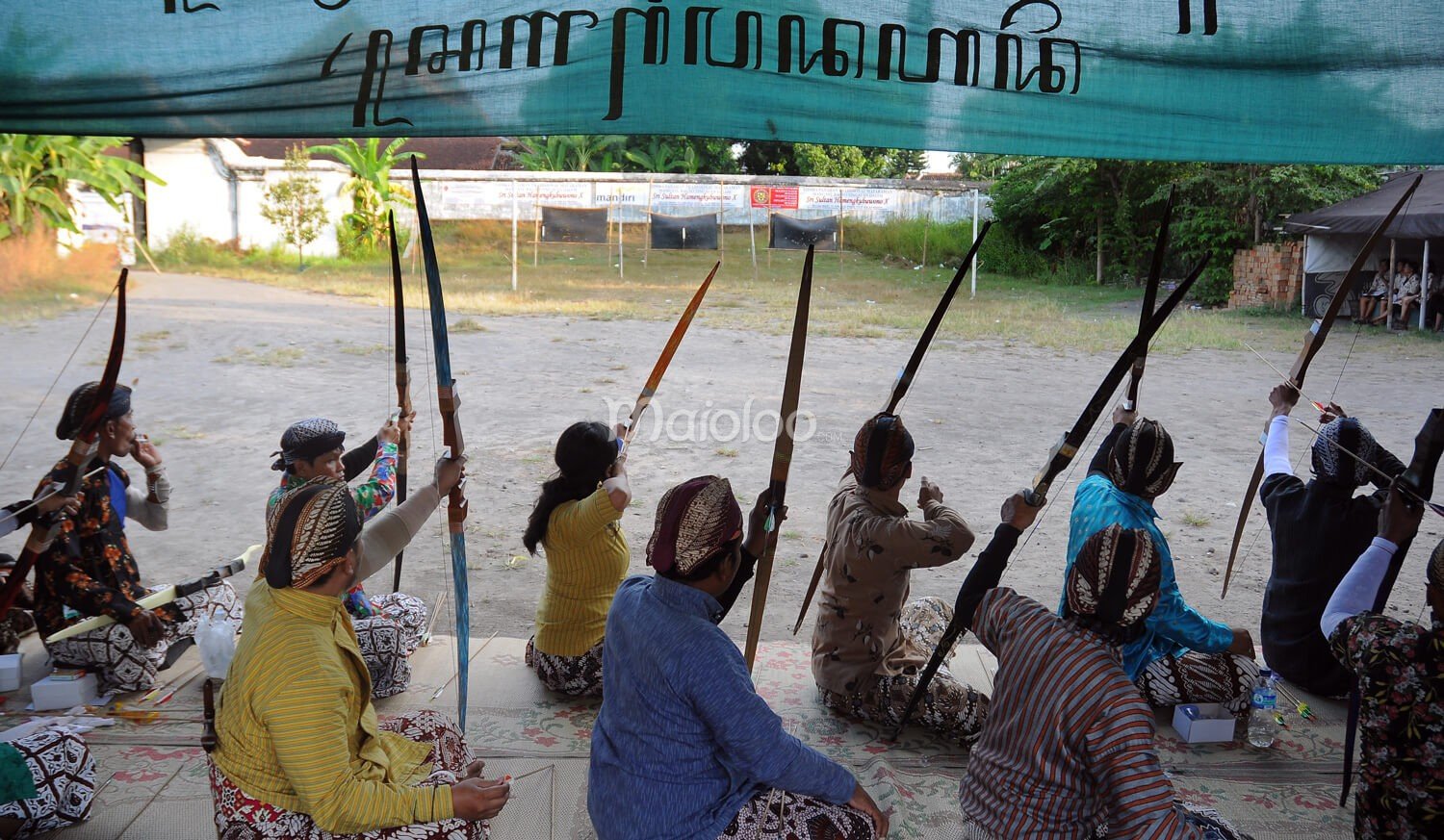 Archers in traditional dress prepare to shoot arrows at targets during Jemparingan.