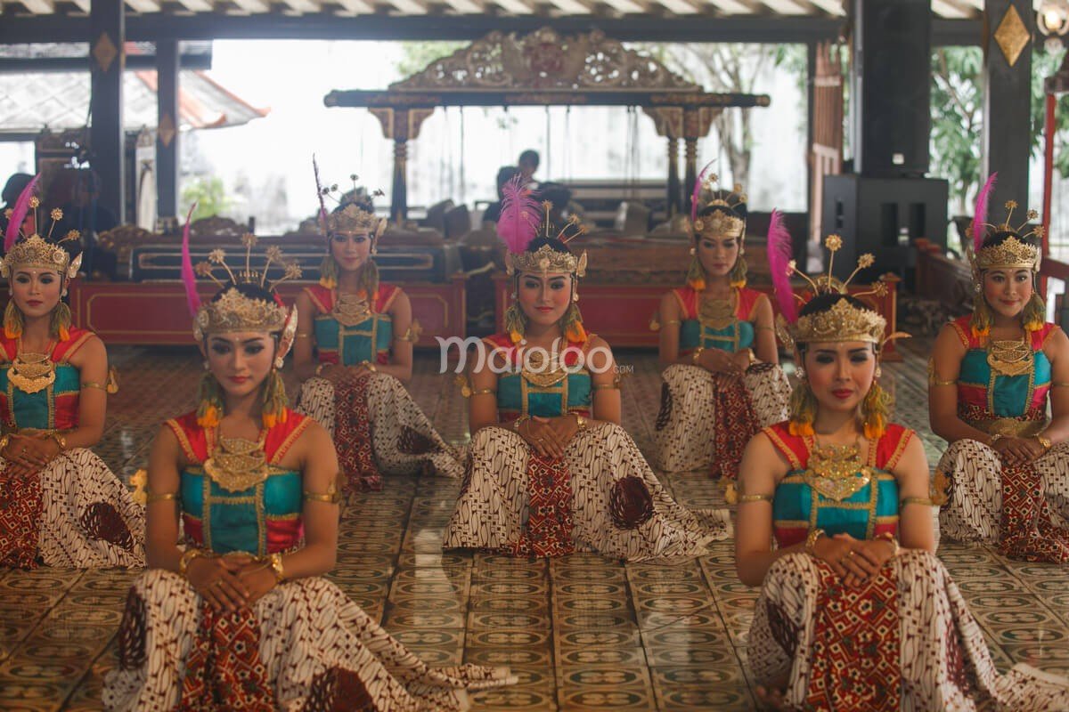 Traditional dancers in intricate costumes performing at Bangsal Sri Manganti in Yogyakarta Palace.