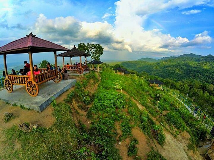 Visitors enjoying the view from wooden gazebos on a hillside at Green Village Gedangsari in Gunungkidul, Yogyakarta.