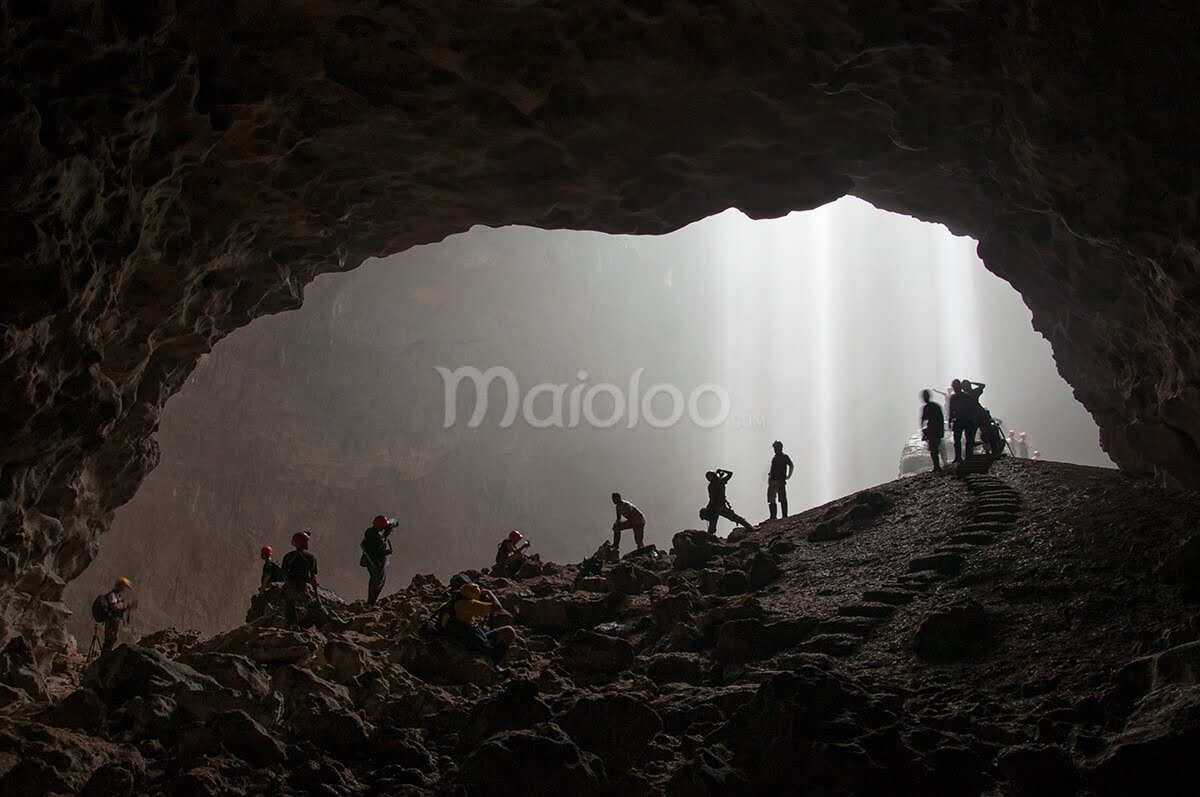 Tourists capturing the light rays streaming into Grubug Cave.